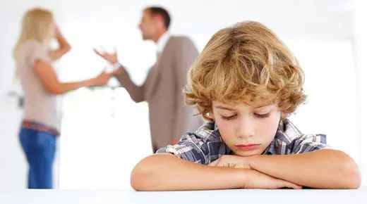 Young boy looking down while parents argue