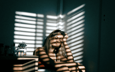 Person sitting with striped blind shadows