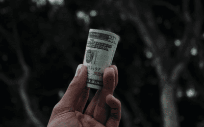 Hand holding rolled US dollar bill