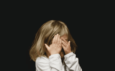Child covering face with hands