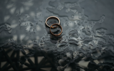 Two gold rings on wet reflective surface