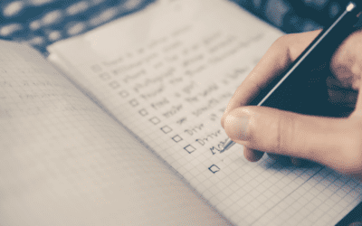 Hand checking items on notebook checklist