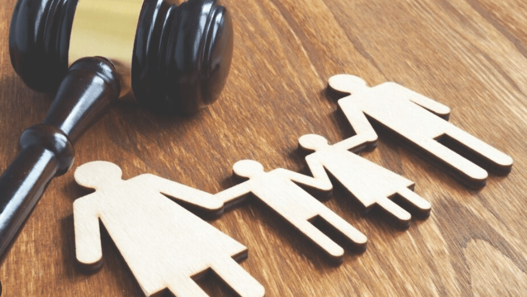 Gavel beside wooden family cutout figures