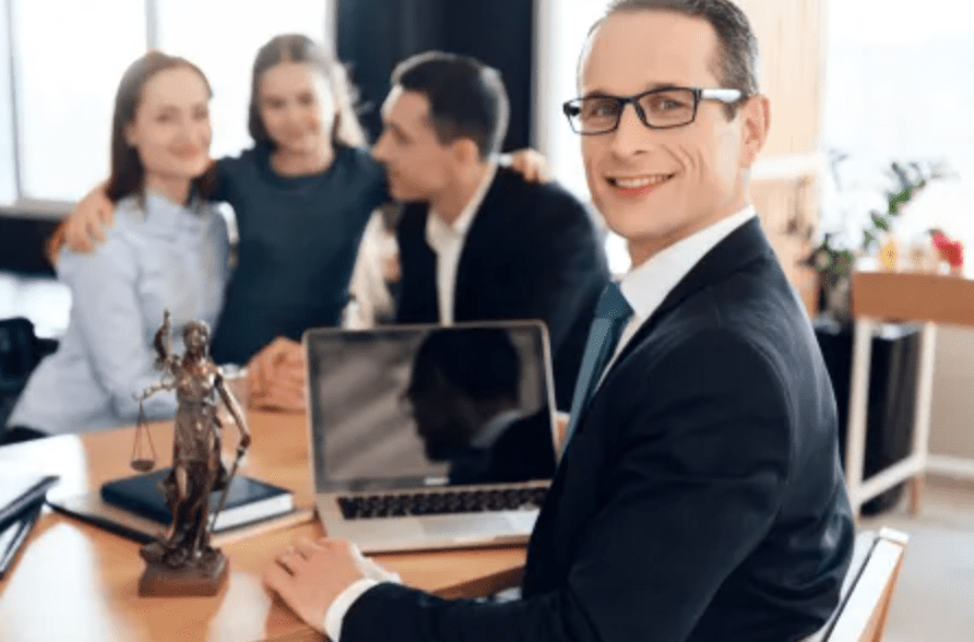 Lawyer smiling at desk with clients