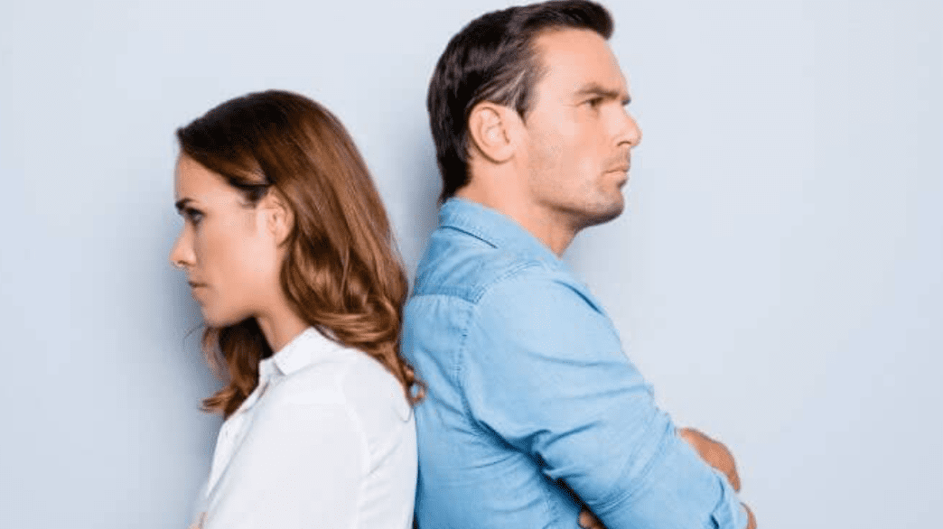 Couple standing back-to-back, arms crossed