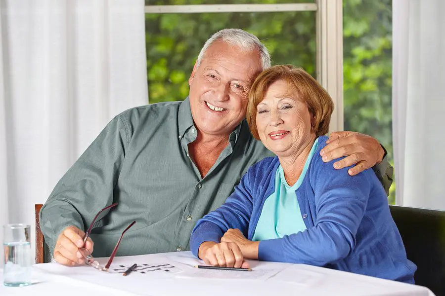 Senior couple smiling at table