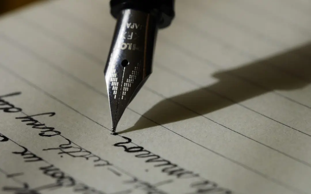 Fountain pen nib writing cursive on paper