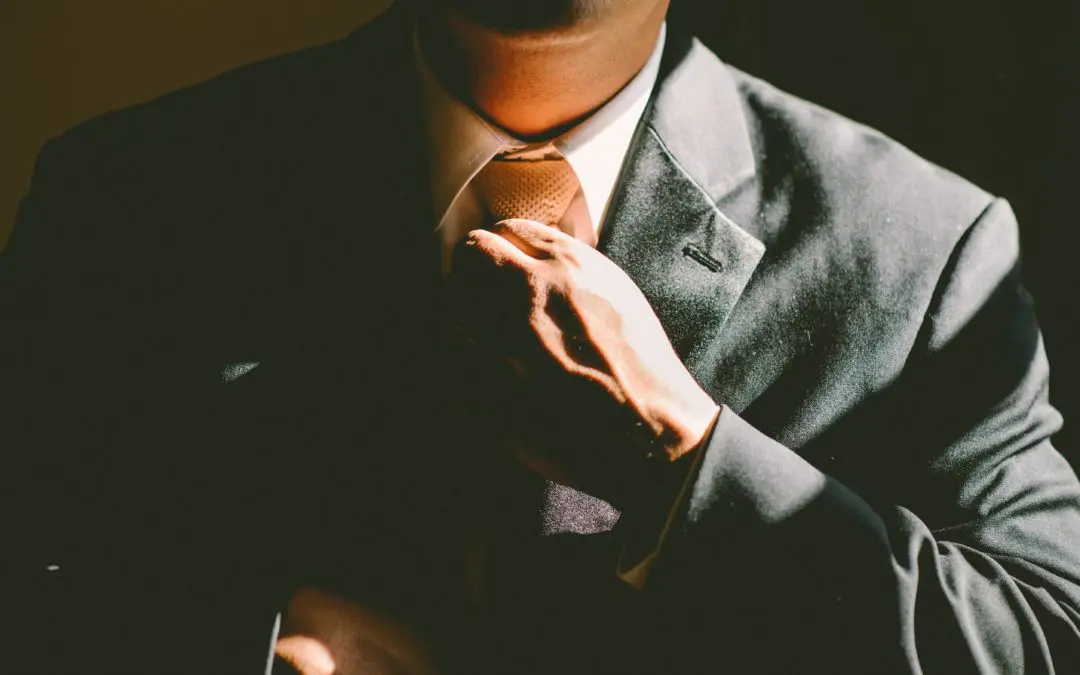 Person adjusting tie in suit