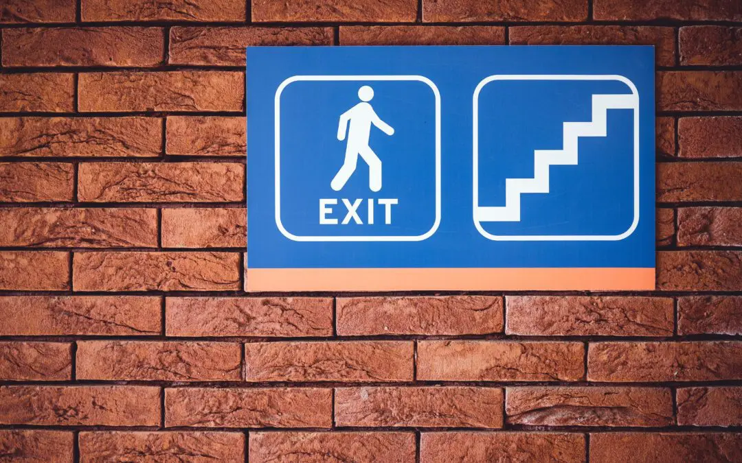 Blue exit and staircase pictogram on brick