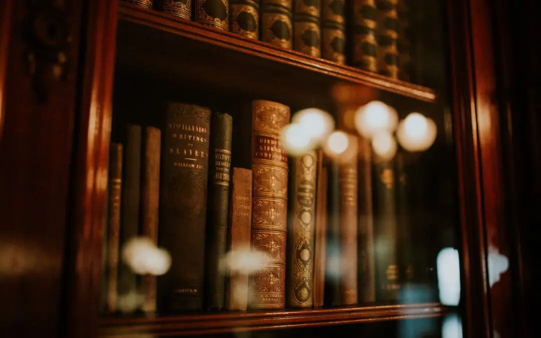 Leather bound vintage books behind glass doors