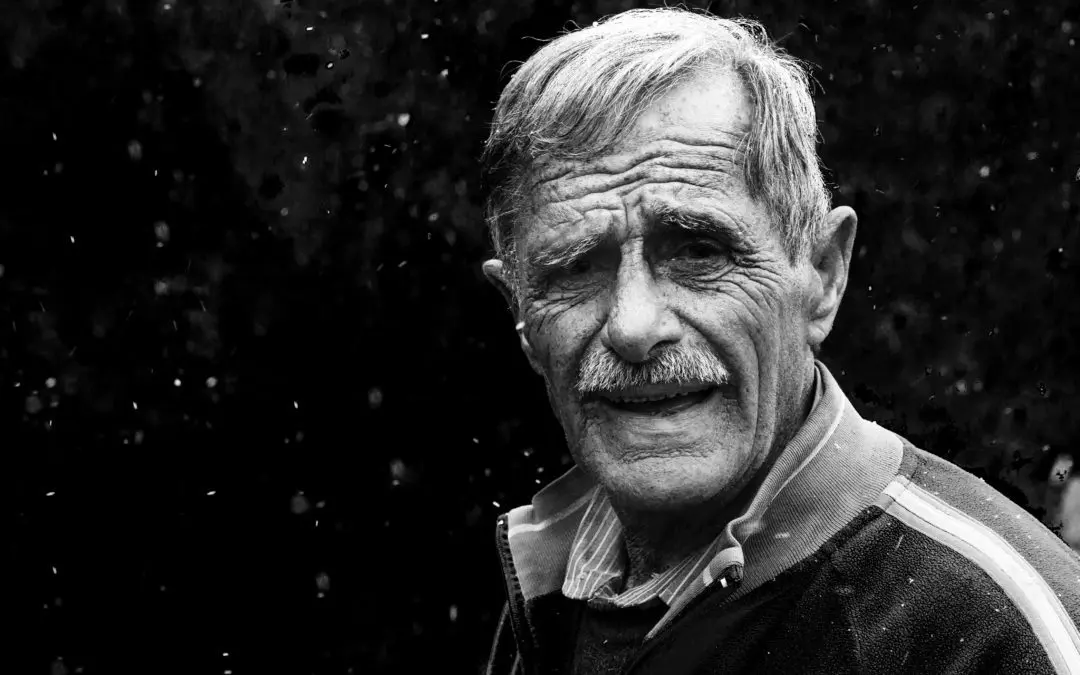 Black-and-white portrait of smiling elderly man