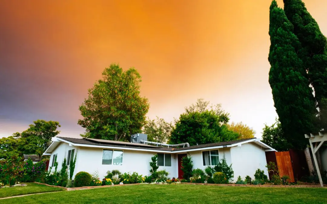 Single story white house under orange sky