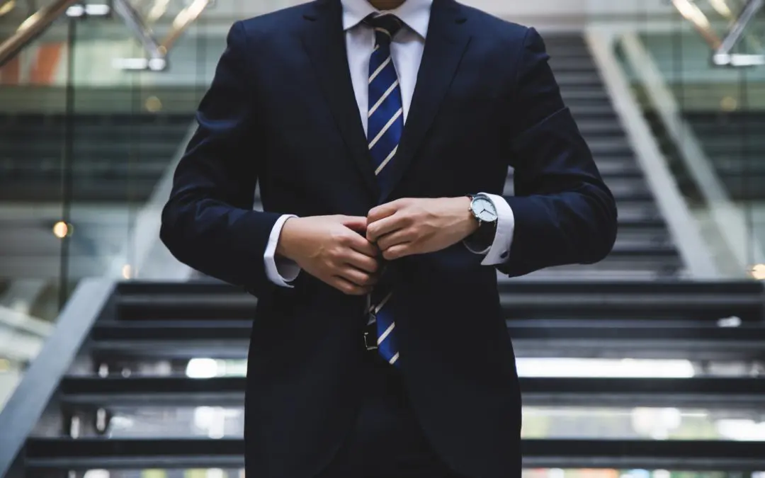 Person in suit adjusting tie on stairs