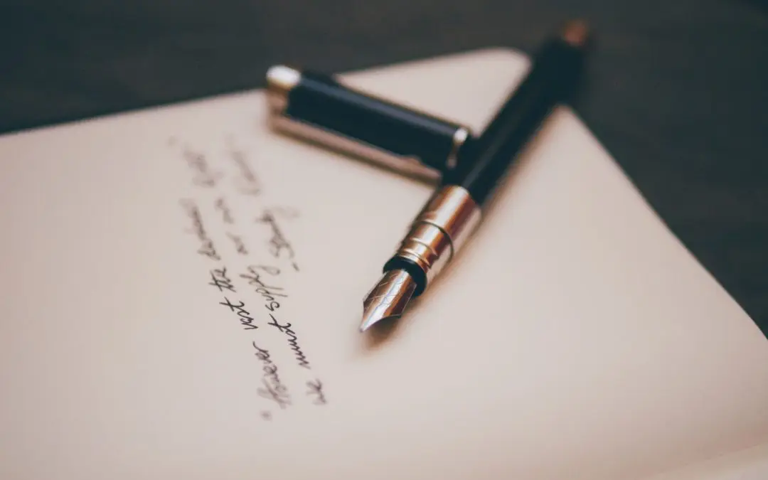 Black fountain pen beside cursive handwriting