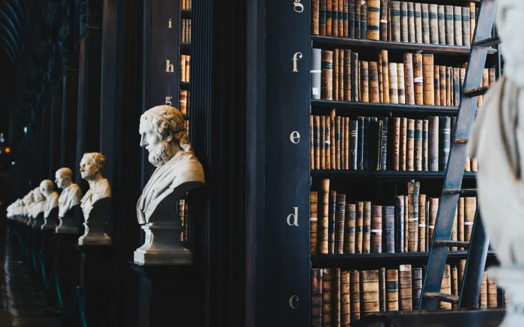 Row of marble busts beside old bookshelves