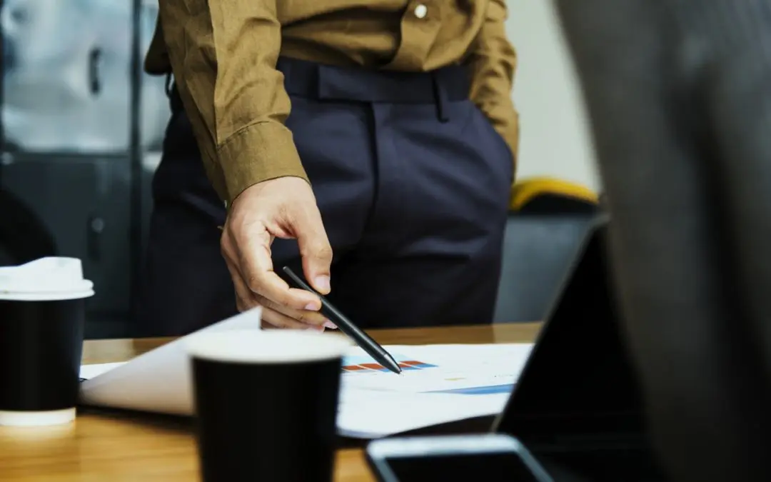 Hand pointing at chart during business meeting