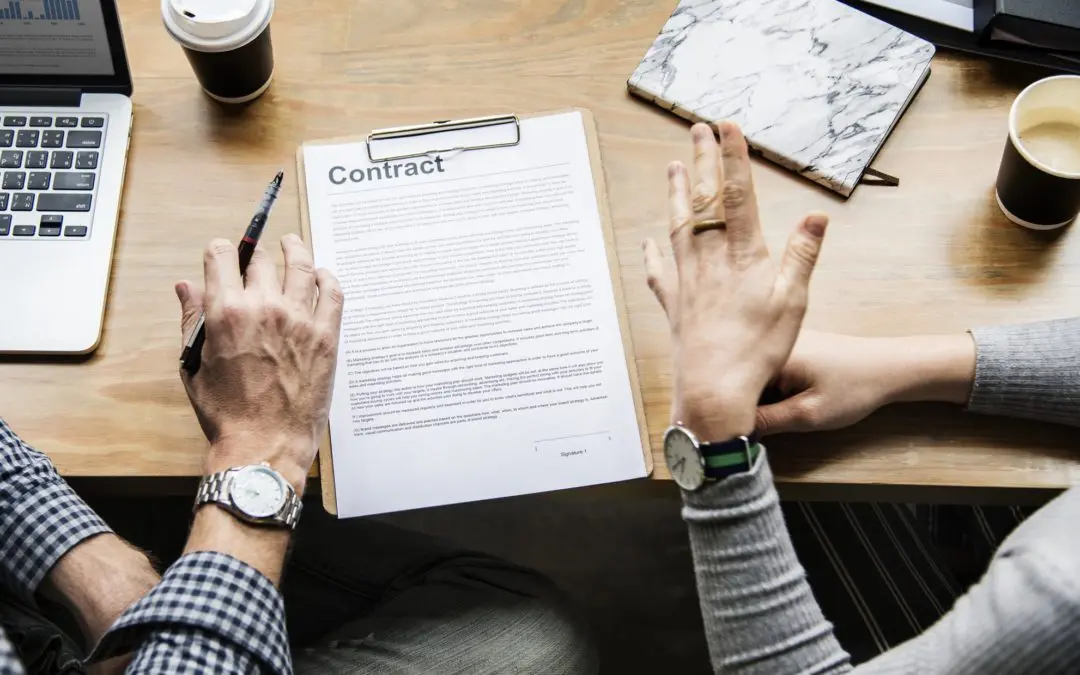 Two people reviewing contract at wooden desk