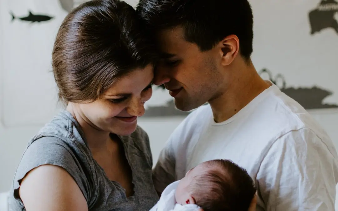 Smiling parents holding newborn baby