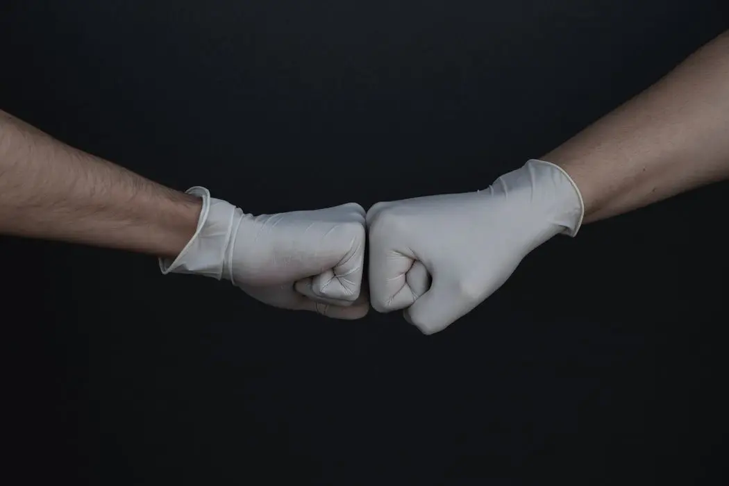 Two gloved hands bumping fists