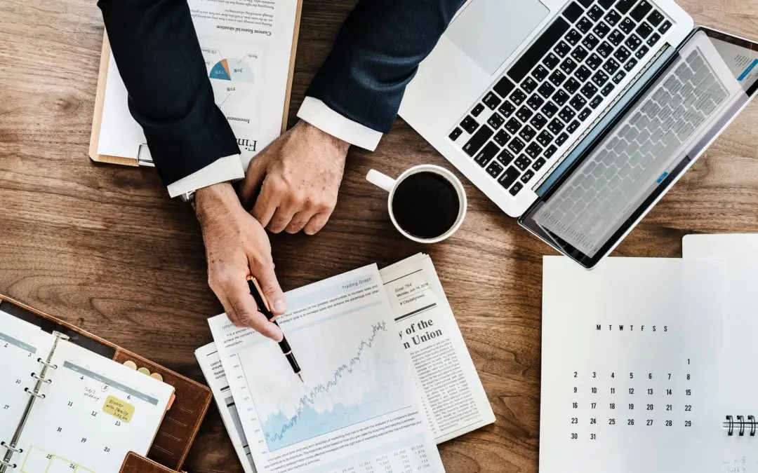 Hands pointing at financial chart on desk