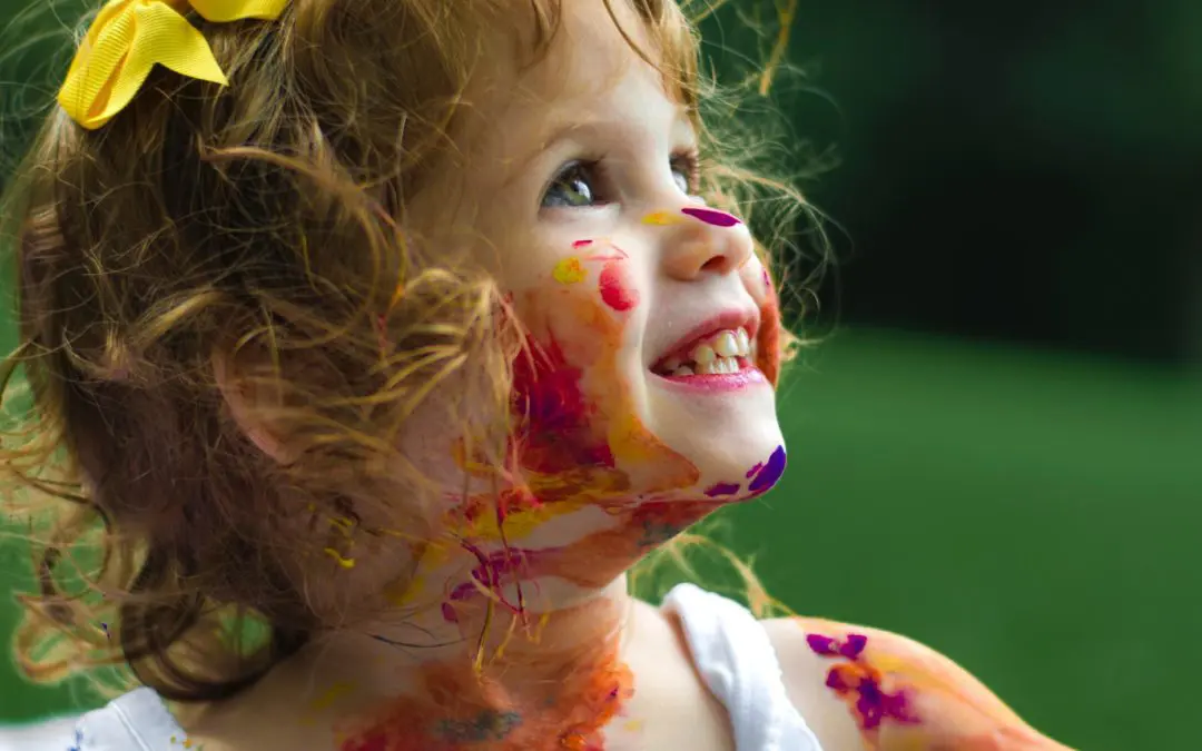 Curly-haired girl with yellow bow and paint