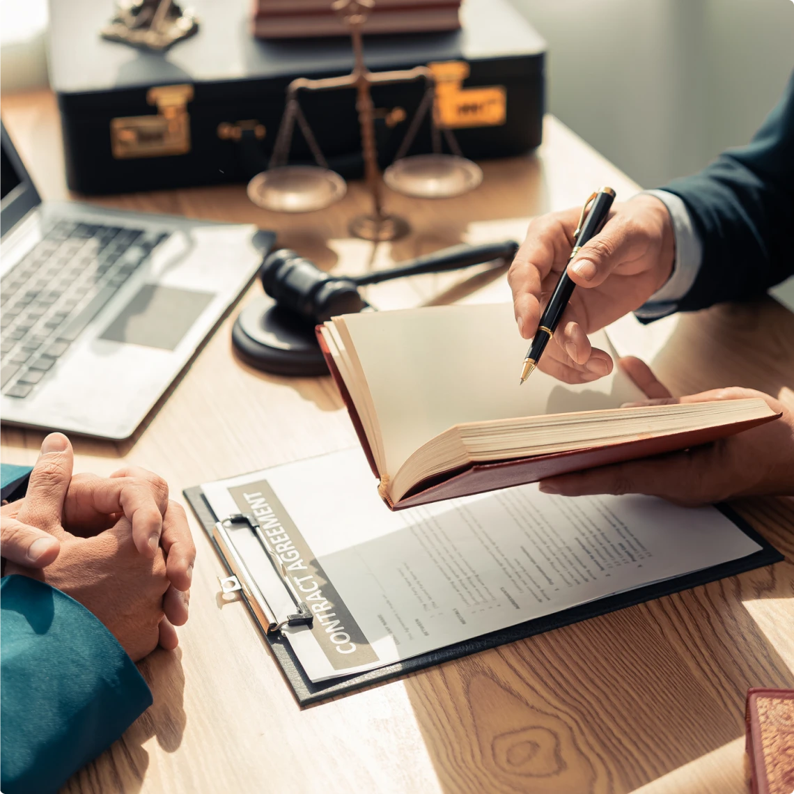 Legal consultation with contract and laptop.