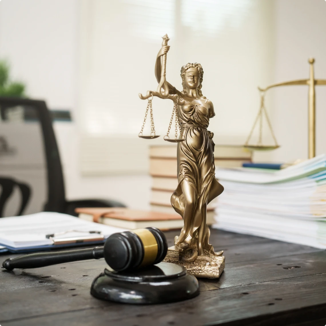 Lady Justice statue with gavel and documents.
