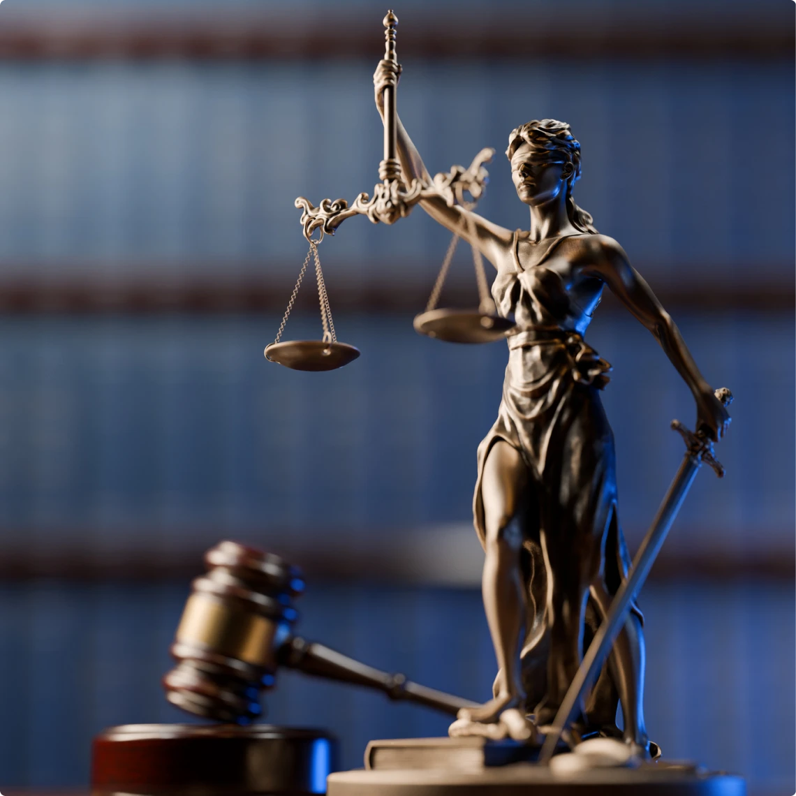 Lady Justice statue with gavel in courtroom.