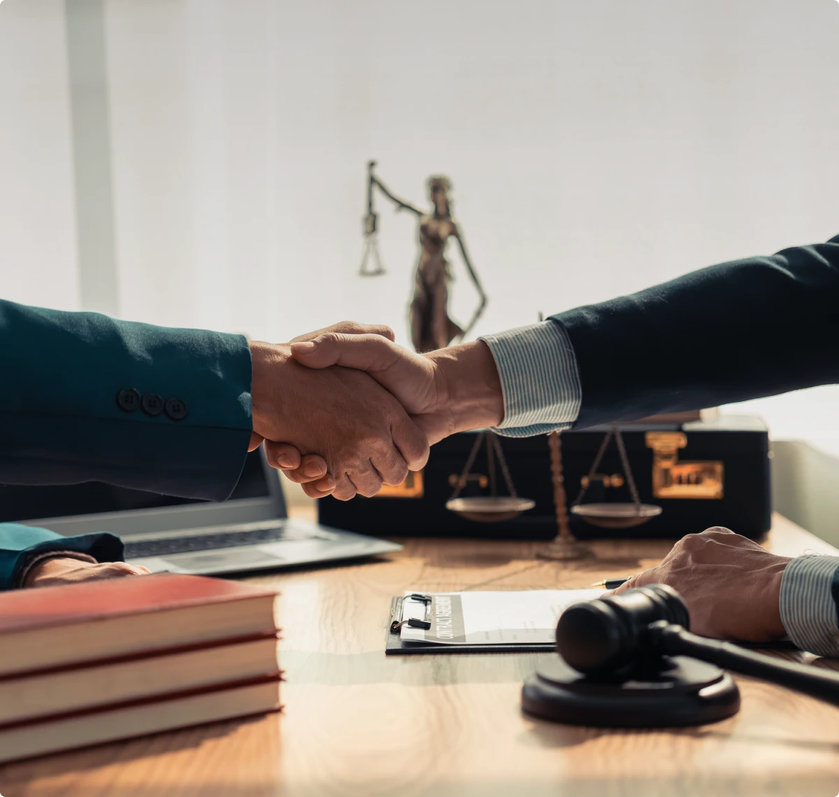Handshake over legal documents and gavel.